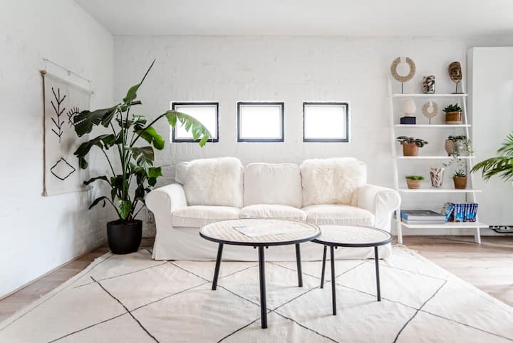 Bright living room with white sofa and plants at Suite Elan